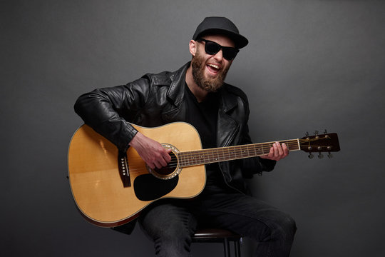 Guitar player with beard and black clothes