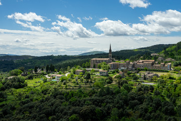 un village et son clocher d'église sur une pente de colline verdoyante