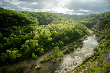 Fototapeta na wymiar vue sur les gorges d'une rivière bordée de forêt, sous la pluie