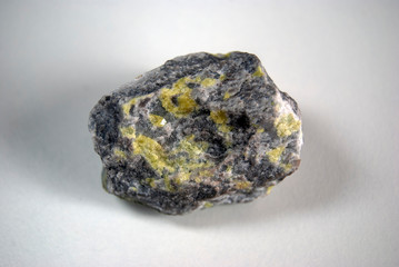 A sample of native sulfur in dolomite on a gray background. Origin: Guardak, Turkmenistan.