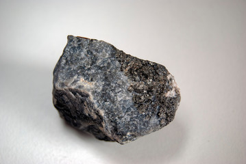 Arsenopyrite specimen (lat. Arsenicum) in the rock on a gray background. Origin: Ural.
