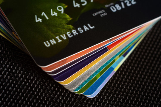 Credit cards are displayed by a fan on a black background.