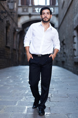 Man in formal clothes strolling past old castle