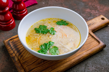 Chicken soup bouillon in a plate on the board