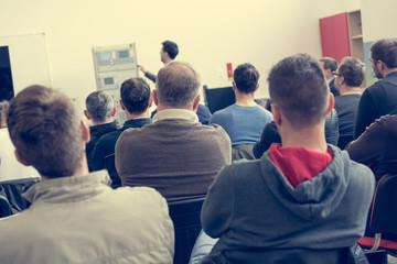 Fototapeta premium Audience at business presentation listening to person giving a speach.