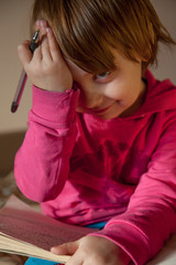 Naklejka premium Difficult education concept. Portrait of beautiful little child girl holding notebook and penr. Humorous photo.