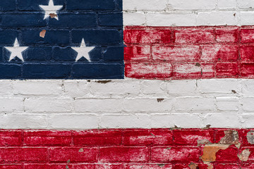 Peeling American flag on brick wall