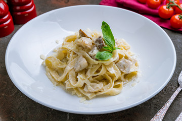 fettuccine with porcini mushrooms on white plate with basil