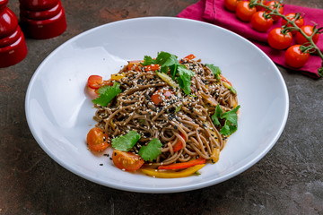 Buckwheat noodles with vegetables on white plate