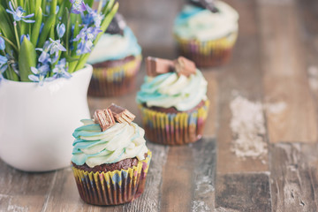 Handmade chocolate muffins with decorations. Book and a bouquet of Scilla