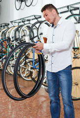 Portrait of male standing with bicylce tires