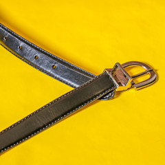 Simple belt and buckle on yellow background