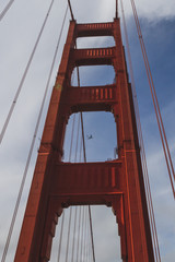 Upward view of Golden Gate Bridge with plane