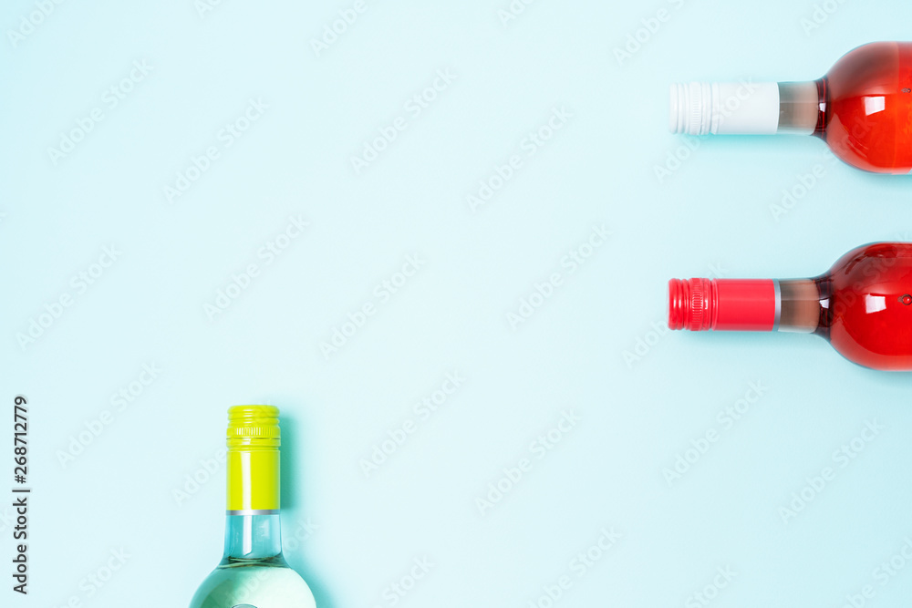 Wall mural layout frame of foil caps in different bright colors of white and rose wine bottles on blue backgrou