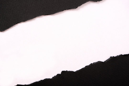 Torn black paper strip diagonal white background