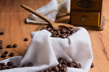  Beautiful coffee beans inside a wooden bowl with a cloth napkin, close up