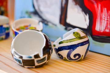 small hand-painted ceramic vases, Close-up of two small hand-painted ceramic decorative pots or trinket dishes, artisan folk art design, unique and colorful craft, horizontal