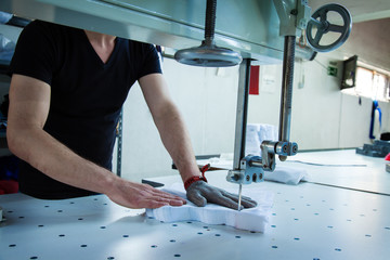 Worker using a machine in factory with iron glove