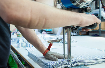 Worker using a machine in factory with iron glove