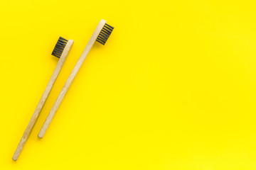 Dental care with eco friendly bamboo tooth brush on yellow background top view space for text