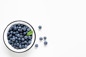 Organic blueberries in bowl on white background. Table top view. Copy space for text