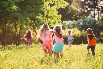 Large group of kids, friends boys and girls running in the park on sunny summer day in casual clothes . © davit85