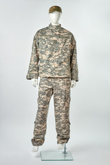 Full-length mannequin in military uniform with cap. Military army camouflage in white isolated background.