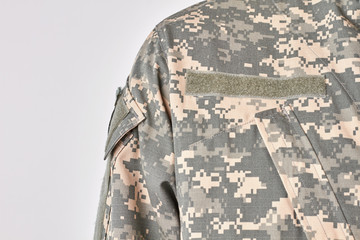 Shoulder of soldier uniform. Extreme close up, white isolated background.