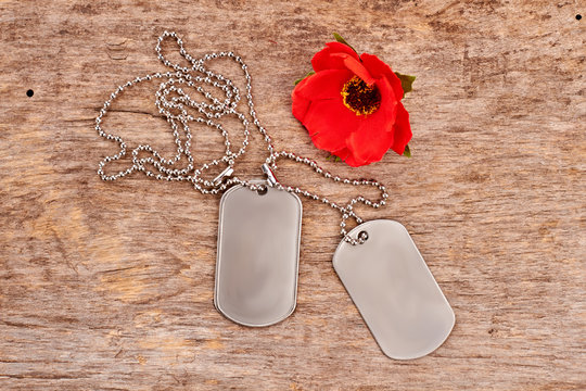 Dog Tags And Red Poppy. Top View, Flat Lay. Wooden Desk Surface Background.