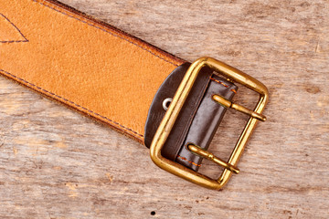 Golden leather belt. Soldier's belt on wood, top view, flat lay.