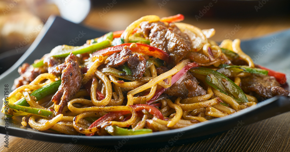 Wall mural asian stir fried noodles with beef peppers and onions panorama