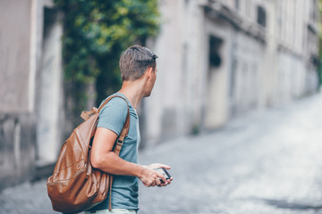 Boy caucasian with smartphone walking in street at Europe