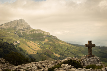Fototapeta premium Standing empty on top of a mountain viewpoint with a cross in Gorbea park. Basque Country, Spain.