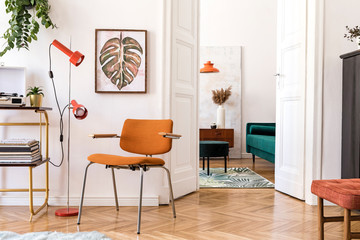 Stylish compositon of retro home interior with mock up poster frame, vintage orange chair, piano, furnitures, design lamps, gold shelf, plants and elegant accessories. Nice home decor of living room. 