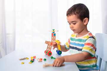 Little boy playing with toy tools and building a vehicle