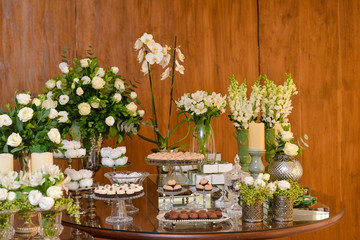 table sweets with flowers, brazilian sweet , chocolate candy, party candy, condensed milk candy balls, chocolate truffles, brigadeiro, chocolate sprinkles, chocolate candy, sweets table