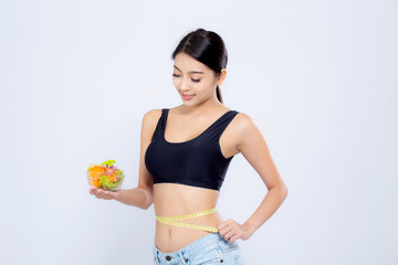 Beautiful young asian woman smiling holding salad vegetable food and measuring waist for weight isolated on white background, girl diet loss with tape measure, health care or wellness concept.