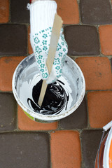 female hands mixed acrylic colors in a plastic box