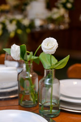 Obraz na płótnie Canvas white roses in glass bottles, natural flowers