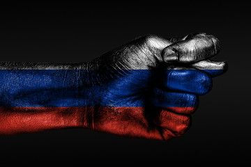 A hand with a painted Russia flag shows a fig, a sign of aggression, disagreement, a dispute on a...