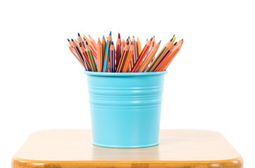 Colored pencils in a blue metallic pencil case on white background..