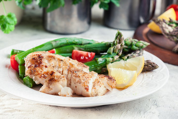 Fried cod fillet with green asparagus