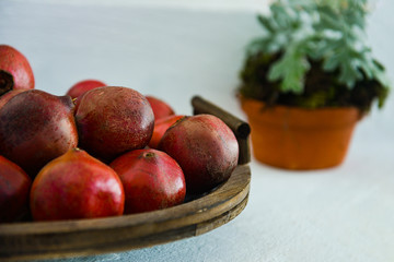 tray with pomegranates, pomegranates in a wooden basket