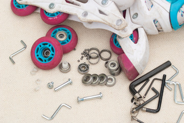 Roller skate bearing replacement. Disassembled roller skates, new and worn bearings, axles,...