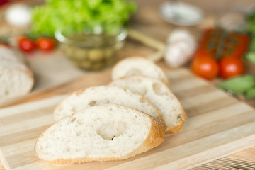 Sliced bread, ciabatta on wooden background. Preparation for the preparation of bruschetta.