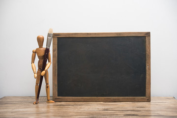 vintage blackboard with wooden frame with wooden doll