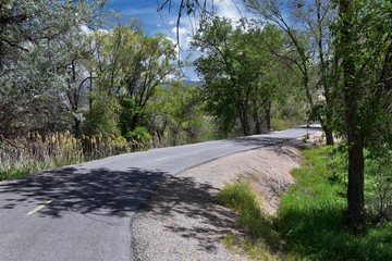 Jordan River Parkway Trail, Redwood Trailhead bordering the Legacy Parkway Trail, panorama views with surrounding trees and silt filled muddy water along the Rocky Mountains, Salt Lake City, Utah. 