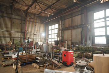 Wide angle shot of metalworking shop crammed with scrap metal and spare parts, copy space