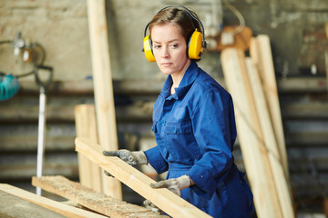Waist up portrait of female worker sorting wood at production factory, copy space