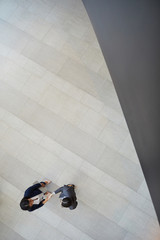  High angle view of multi-ethnic business ladies standing in office lobby with gray tile floor and...